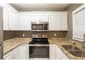 A bright kitchen featuring granite countertops, stainless steel appliances, and white cabinets at 285 Argus Nw Cir, Atlanta, GA 30331