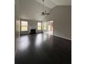 Open living room with hardwood floors, a fireplace, and large windows offering ample sunlight at 4976 Notting Glen Ln, Snellville, GA 30039