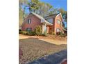 Two-story brick house featuring a lush, pine-covered front yard, providing natural beauty at 3260 Henderson Mill Rd # A, Atlanta, GA 30341