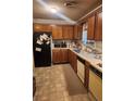 Functional kitchen with wooden cabinetry and appliances, including a black refrigerator at 3846 Narron Sw Dr, Atlanta, GA 30331