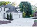 Spacious driveway leads to a three-car garage, with landscaped accents at 3258 Bransley Way, Duluth, GA 30097