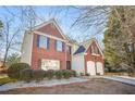 Brick home with a manicured landscape and a driveway leading to a two-car garage at 854 Malvern Blvd, Stone Mountain, GA 30087