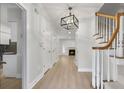 Bright hallway featuring wood floors, white trim, decorative lighting, and a glimpse of the living room with a fireplace at 1160 Windsor Pkwy # 13, Atlanta, GA 30319