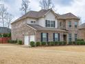 Two-story brick home with a turret, two-car garage, and manicured lawn at 600 Lockerbie Ter, Mcdonough, GA 30252