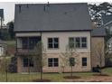 Home's rear exterior with a covered porch, multiple windows, and a well-maintained lawn at 2235 Windsor Bluffs Dr, Cumming, GA 30041