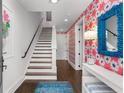 Staircase entrance with colorful wallpaper, a blue mirror, and hardwood floors at 304 Stonemont Dr, Atlanta, GA 30305