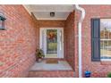 Close-up of a charming red brick home's front porch featuring a decorated glass door and white trim at 868 Clarion Way, Lawrenceville, GA 30044