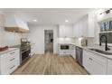 Bright, renovated kitchen with custom white cabinets, modern appliances, and stunning hardwood floors at 5548 Martina Way, Atlanta, GA 30338