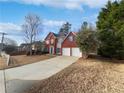 Traditional home with red brick, blue shutters, a blue front door, and a long driveway at 730 Taylor School Dr, Lawrenceville, GA 30043