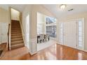 Bright foyer with hardwood floors, staircase, and a view into the formal dining area; naturally lit at 1135 Chandler Ridge Dr, Lawrenceville, GA 30045