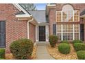 Inviting front entrance features a brick facade, complemented by lush greenery and decorative rock ground cover at 1135 Chandler Ridge Dr, Lawrenceville, GA 30045