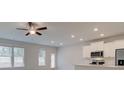 Bright living room with fan, recessed lighting, and a partial view of the kitchen at 312 Shine Dr, Stockbridge, GA 30281