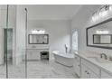 Modern bathroom with a standalone tub, white marble floors, dual sinks, and glass enclosed shower at 5990 Somerset Ct, Suwanee, GA 30024