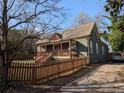 Charming home with a covered front porch and wooden fence, showing the driveway and well-maintained yard at 3124 Usher Nw St, Covington, GA 30014