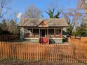 Exterior view of a fenced home featuring a covered porch with traditional design and mature trees at 3124 Usher Nw St, Covington, GA 30014