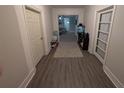 Hallway with light gray walls, wood-look flooring, and doors leading to other rooms in the house at 3124 Usher Nw St, Covington, GA 30014