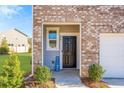 Inviting front entry with a welcome sign, brick facade, and manicured landscaping at 579 Magnolia Cir, Palmetto, GA 30268