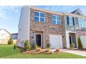 A beautiful townhome with a brick facade, green lawn, and a private garage at 579 Magnolia Cir, Palmetto, GA 30268