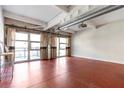 Living room featuring exposed ductwork, red floors, and large windows with decorative curtains at 806 Marcus Se St # 21, Atlanta, GA 30316