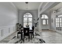 Elegant dining room featuring modern chandelier, wainscoting, and large arched window at 2860 Chardonnay Ln, Cumming, GA 30041