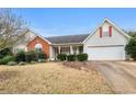 Well-maintained single-Gathering home with a two-car garage and landscaped front yard on a sunny day at 40 Berkshire Run, Covington, GA 30016