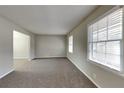 Bright living room with neutral paint, carpet flooring, and large windows offering plenty of natural light at 1848 Englewood Way, Snellville, GA 30078