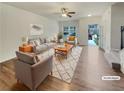 Bright living room featuring a ceiling fan, neutral walls, and wood-look flooring at 6077 Oakley Rd, Union City, GA 30291