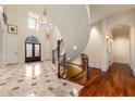 Elegant foyer featuring a curved staircase, marble floors, and a stunning chandelier at 4266 Woodland Brook Se Dr, Atlanta, GA 30339