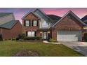 Charming two-story brick home with well-manicured lawn and attached two-car garage at 480 Glenns Farm Way, Grayson, GA 30017