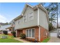 Side view of a well-maintained two-story home featuring brick and gray siding, and a green lawn at 4893 Autumn Cir, Stone Mountain, GA 30088