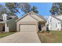 Inviting beige brick home with a two-car garage, professionally landscaped yard, and cozy front entryway at 2208 Croghan Dr, Hampton, GA 30228