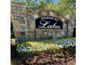 Stone Thompson Mill Lakes community sign surrounded by colorful flowerbeds at 3499 Lake Mill Rd, Buford, GA 30519