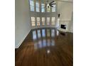 Bright living room with large windows, fireplace, and gleaming hardwood floors at 3499 Lake Mill Rd, Buford, GA 30519