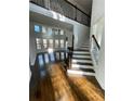 Bright living room with hardwood floors, large windows, and staircase to second floor at 3499 Lake Mill Rd, Buford, GA 30519