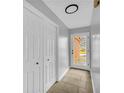 Hallway with tile flooring, closet, and view of the front yard through a glass door at 221 The Esplanade Se Way, Loganville, GA 30052