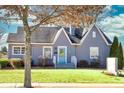 Charming home featuring a neatly manicured lawn, quaint front porch, and a cheerful turquoise front door at 449 South Hill St., Buford, GA 30518