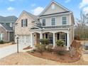 View of a charming two-story home featuring a brick facade, siding accents, and a covered front porch at 3650 Bentbill Xing, Cumming, GA 30041