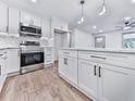 Well-lit kitchen with stainless appliances, island with marble countertop, and ample cabinet space at 221 Wonewok Dr, Canton, GA 30114