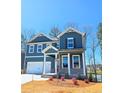 Craftsman-style home with blue siding, white trim, a covered entry, and a well-manicured front lawn at 2359 Brown Dove Way (Lot 2), Grayson, GA 30017