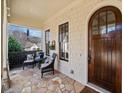 Inviting front porch with stone flooring, comfortable seating, and a beautifully crafted wooden door at 3015 Woodvale Ct, Alpharetta, GA 30022