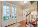 Inviting foyer featuring hardwood floors, staircase, and French doors at 1849 Linnet Ne Ct, Roswell, GA 30075