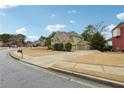 Suburban home featuring well-maintained landscaping, a three car garage, and a paved driveway at 1412 Great Shoals Dr, Lawrenceville, GA 30045