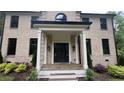 Welcoming front entrance with a classic black door framed by white columns and manicured greenery at 805 Wesley Oak Rd, Sandy Springs, GA 30328