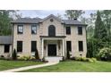 Elegant brick home featuring a stately front entrance with white columns and landscaped walkway at 805 Wesley Oak Rd, Sandy Springs, GA 30328