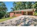 Well-kept brick home featuring a carport and a long, sloped driveway at 2837 Davidson Dr, Lithonia, GA 30058