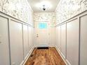 Bright entryway features wood floors, white wainscoting, and stylish wallpaper at 1659 Olympian Sw Way, Atlanta, GA 30310