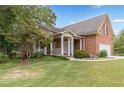 Brick home with a welcoming front porch, lush lawn, and side-entry garage at 180 Winecoff Dr, Fayetteville, GA 30214