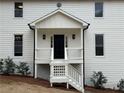 Inviting front porch with classic white railings and a stylish black front door at 3663 Heatherwood Ne Dr, Marietta, GA 30066