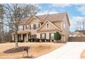 A well-maintained home with a pristine lawn, long driveway, and lush landscaping on a partially cloudy day at 2600 Reece Farms Sw Trl, Powder Springs, GA 30127