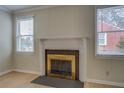 Fireplace with white mantel, flanked by two windows, and hardwood floors at 4131 Carroll Sw St, Covington, GA 30014